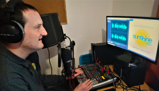 Programme Controller Steve Ledbrook editing audio messages at home.